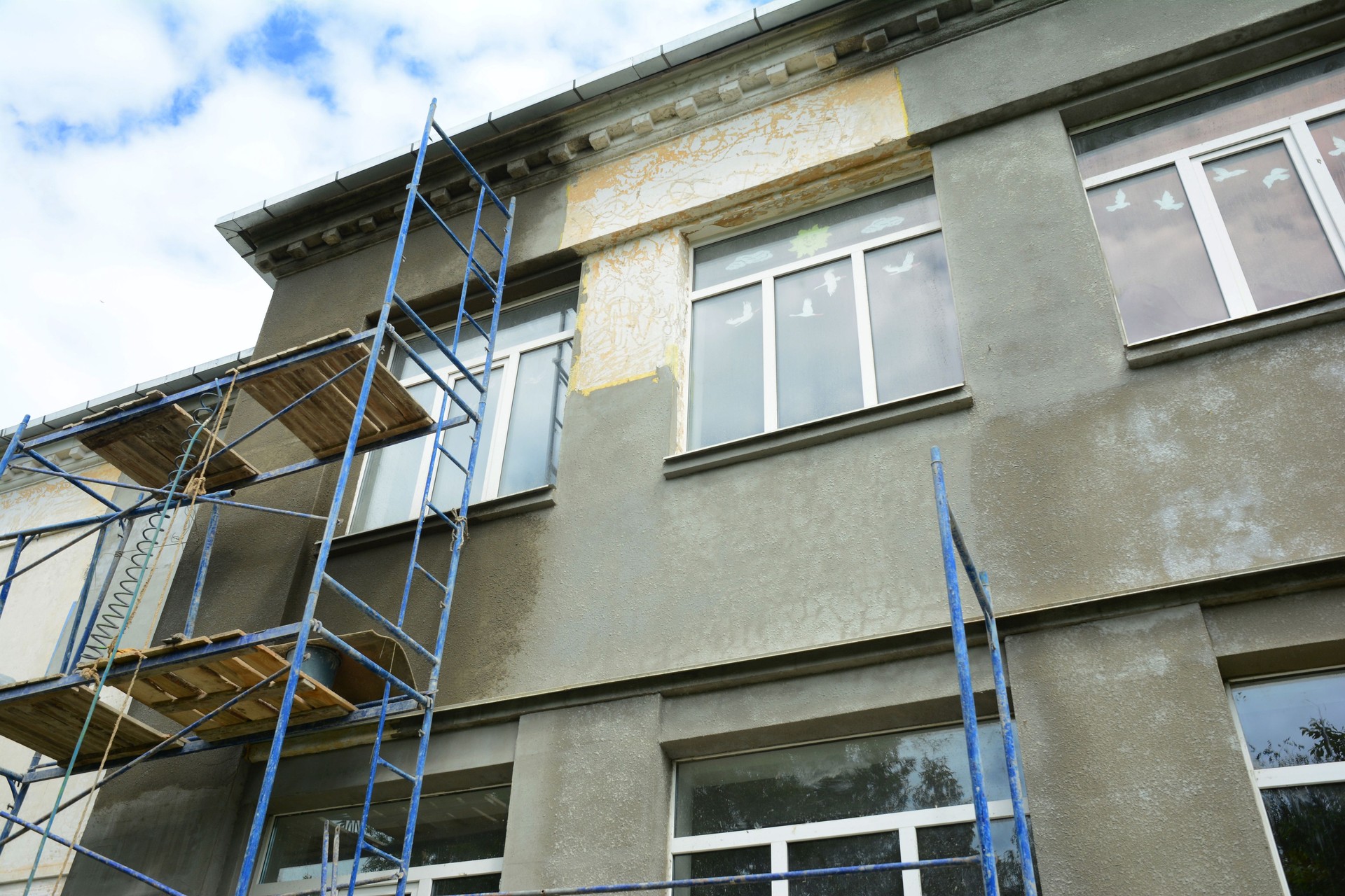 House facade wall renovation with new plastering and stucco before paint.